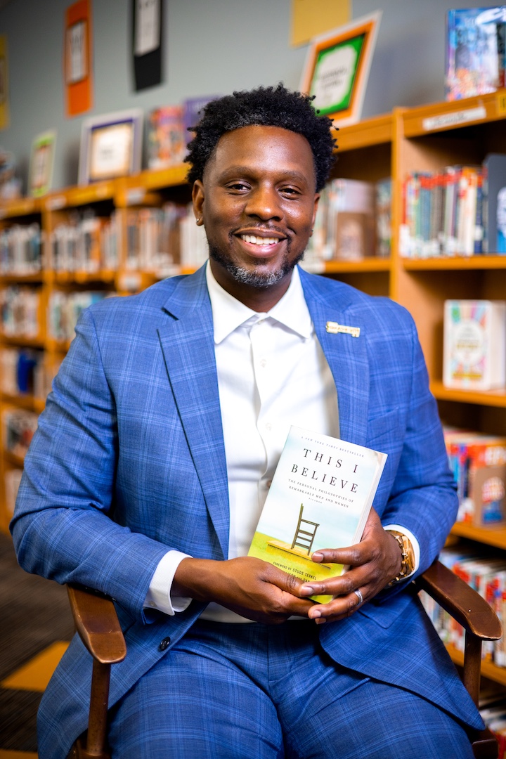 Stephen Nobles holding a book in a library