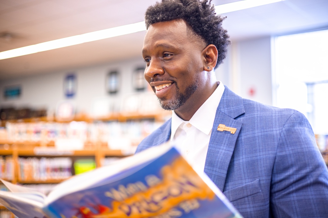 Stephen Nobles engaging with a book in a school library